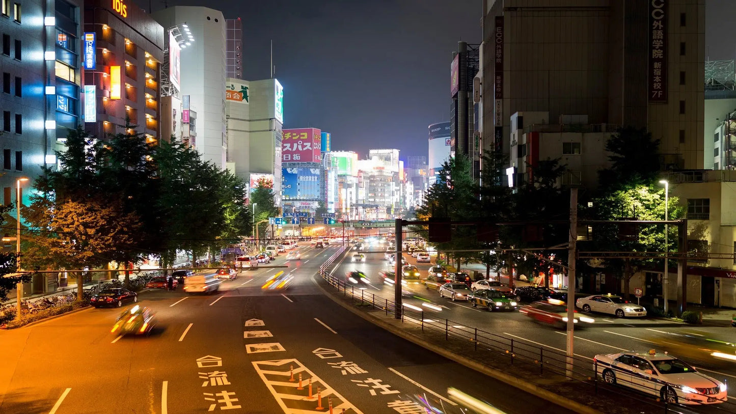 a road at night with many cars and big buildings as travel target for esim