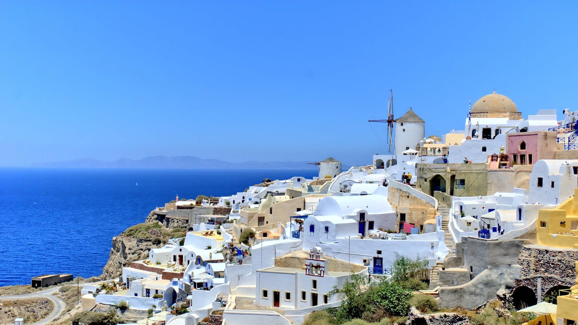 old greek buildings on front of a blue sea as travel target for esim